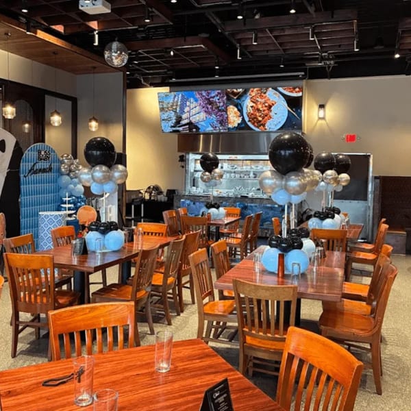 Restaurant dining room decorated with black, silver, and blue balloons for a "Boss Baby" themed event.